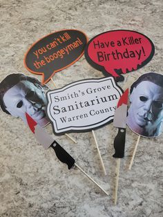 four halloween photo props on top of a granite counter with the words, you can't kill the postman have a killer birthday