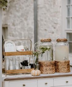 two jars with flowers in them sitting on top of a table next to other items