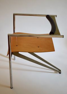 a wooden chair with metal legs on a white surface and a black object in the back