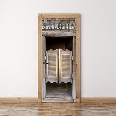 an old wooden door with shutters open in front of a white wall and wood floor