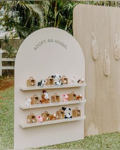 there is a display in the grass with small animals on it and paper bags hanging from the shelves