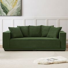 a green couch sitting on top of a white rug