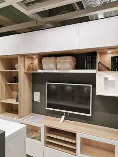 a tv is mounted on the wall in front of some bookshelves and shelves