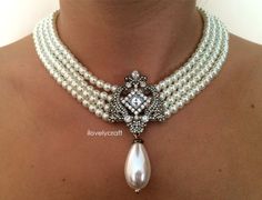 "Collar de perlas que comprende cuatro hebras de perlas blancas brillantes con un broche central con muchas pedrería brillantes y una gran perla colgante con forma de lágrima. Inspirado en la joyería Great Gatsby y la joyería de la década de 1920. Perfecto para una fiesta de la década de 1920, bodas vintage, una novia de inspiración vintage (Art deco) o incluso una fiesta temática de Downton Abbey. El acabado adecuado es Antique/Vintage Gold Plated. El collar está hecho con una cadena extensora Gatsby Attire, 1920s Downton Abbey, Gaudy Jewelry, Bridesmaid Pearl Necklace, Vintage Bridal Necklace, Great Gatsby Headpiece, Downton Abbey Dresses, Flapper Wedding, Gatsby Jewelry