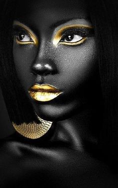 a woman with black and gold makeup is posing for the camera, she has her face painted yellow