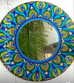 a circular mirror with blue and green designs on it