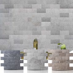 three sinks are shown in front of a wall made out of squares and rectangles