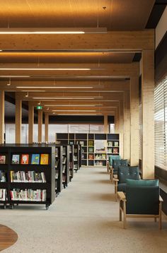 an empty library with chairs and bookshelves full of books in the middle of it