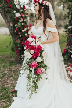 a woman in a wedding dress holding a bouquet of flowers