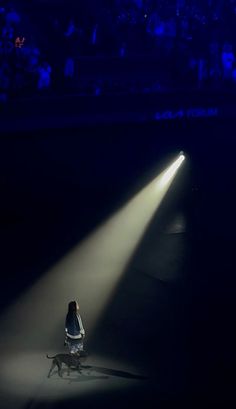 a person sitting in the middle of a stage with a dog