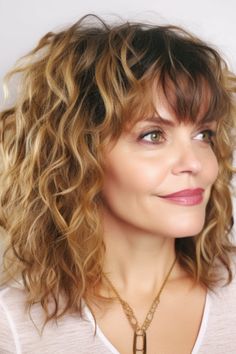 Achieve a youthful, bohemian vibe with shaggy curls and fringe. Perfect for naturally curly or wavy hair, this look will add volume and texture. Click here to check out more vibrant hairstyles & haircuts for women over 50. Curly Hair Bob Haircut With Bangs, Medium Length Shag Haircuts With Bangs Curly, Wavy Shaggy Haircuts, Curly Shag With Bangs Over 40, Medium Curly Shag Haircuts, Curly Hairstyles With Fringe, Curly Bob Hairstyles With Bangs, Wavy Hair Cuts With Bangs, Medium Length Wavy Hair With Bangs