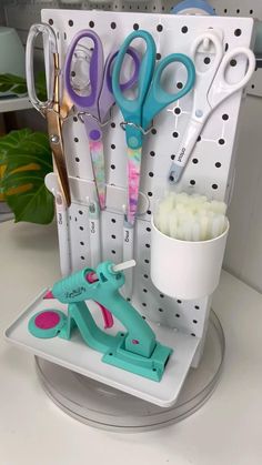 scissors and other crafting supplies are displayed in a holder on a counter top with polka dots