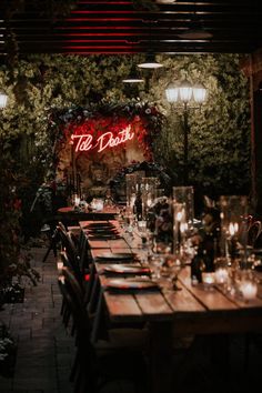 a long table with candles and place settings in front of a sign that says the detroit