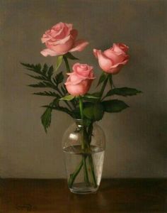 three pink roses in a glass vase on a table