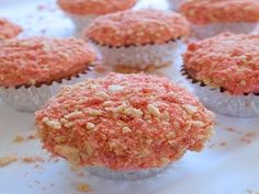 several cupcakes with pink frosting and sprinkles