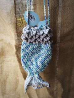 a crocheted blue and white fish ornament hanging from a string