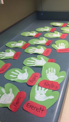 several handprints are arranged on the floor in front of a table with red and green hearts