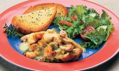 a blue plate topped with bread and salad next to a slice of cheese covered sandwich