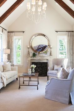 a living room filled with furniture and a fire place under a mirror on the wall