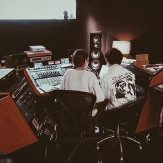 two people sitting in front of sound mixing equipment