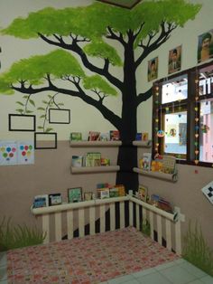 a child's room with a tree painted on the wall and bookshelves