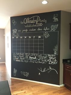 a chalkboard in the corner of a room with writing on it and calendars