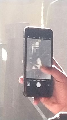 a person holding up a cell phone to take a picture with the screen on their hand