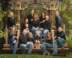 a group of people sitting on top of a wooden bench in front of a gazebo