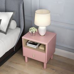 a pink nightstand next to a bed in a bedroom