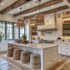 a large kitchen with lots of counter space and wicker baskets hanging from the ceiling