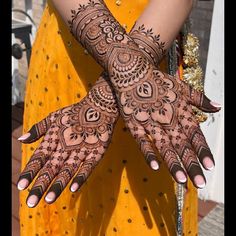 a woman's hands with hennap on her arm and hand, decorated with intricate designs