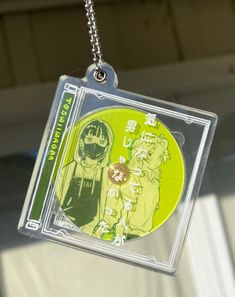 a cd case hanging from a chain with an image of two people on the disc