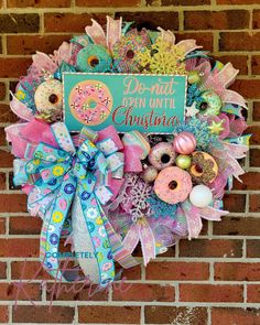 a wreath that has donuts on it and is hanging on the side of a brick wall