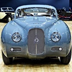 an old blue car is on display in a museum