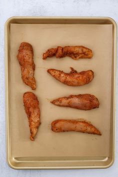 four pieces of chicken sitting on top of a baking pan next to another piece of meat