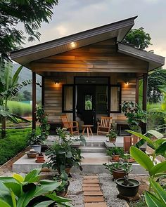 a small wooden house surrounded by greenery and potted plants