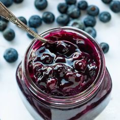 blueberry sauce in a jar with a spoon