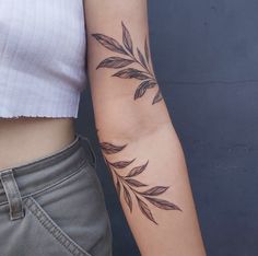 a woman's arm with leaves on it