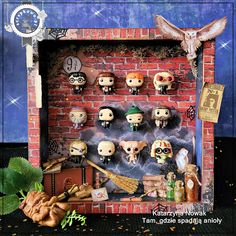 an assortment of halloween figurines on display in front of a brick wall with a clock