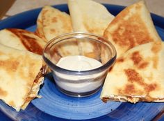 some pita bread on a blue plate with a dipping sauce