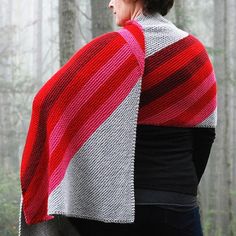 a woman wearing a red and grey shawl in the woods