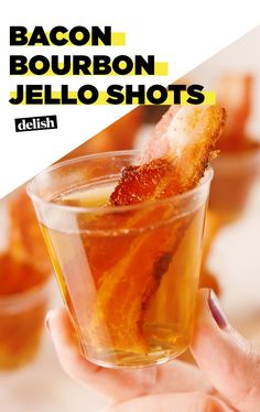 bacon bourbon jello shots in a glass being held up by someone's hand