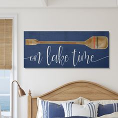 a bedroom with a bed and a wooden sign on the wall above it that says, on paddle time