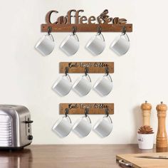 there is a coffee sign on the wall with mugs hanging from it's hooks