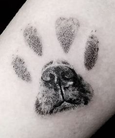 an animal's paw print is shown in black and grey ink on the arm