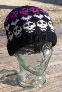 a knitted hat sitting on top of a glass head