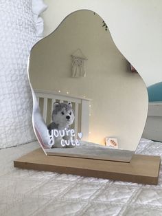 a mirror that has a stuffed animal in it on a wooden stand with the words you're cute