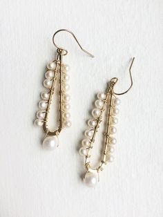 A celebration of pearls in a modern style. A larger pearl dangles from the bottom while smaller pearls line the long teardrop. + Pearls. 14K Gold Filled Ear Wire. 14K Gold Plated Teardrop. + Earrings measure 2.5 inches (6.3 cm) in length. + Earrings take 1 business day to make. + Your jewelry will come in a jewelry box, tied with a ribbon. ➤➤ Have a question about this product, reach out to me here ➙ https://www.etsy.com/conversations/new?with_id=9057464&referring_id=5772224&referring_ty Teardrop Pearl Drop Chandelier Earrings For Party, Pearl Teardrop Dangle Earrings With Pearl Drop, Pearl Drop Teardrop Dangle Earrings, Elegant Teardrop Crown Pearl Drop Earrings, Elegant Chandelier Earrings With Dangling Beads For Celebration, Teardrop Pearl Chain Earrings, Teardrop Pearl Chain Earrings For Anniversary, Elegant Teardrop Pearl Earrings With Dangling Beads, Elegant Teardrop Earrings With Dangling Beads Gift