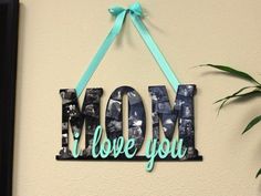 a wooden sign that says mom love you hanging on a wall next to a potted plant