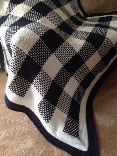 a black and white checkered blanket sitting on top of a bed